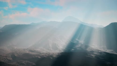 Vue panoramique de la lumière du soleil traversant les nuages au-dessus des montagnes majestueuses