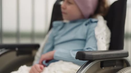 Child in Wheelchair Smiling and Giving Thumbs Up
