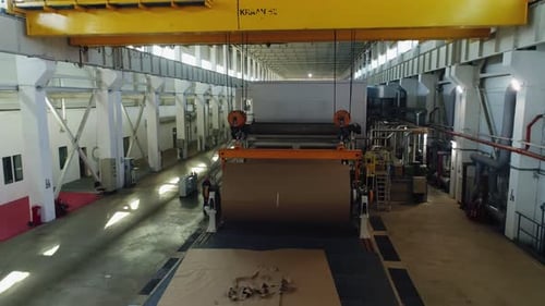 Large Paper Roll on Black Conveyor Belt in Modern Workshop