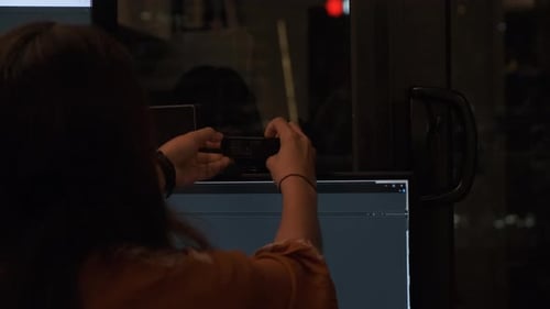 Woman Adjusts Webcam on Computer at Night