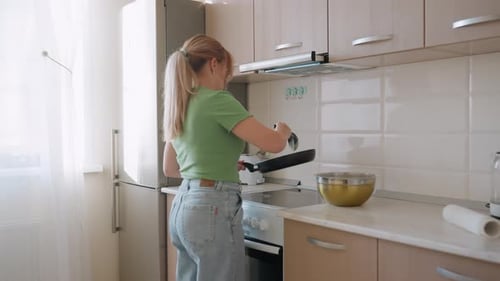 Woman Cooking Pancakes in Bright Kitchen with Ease