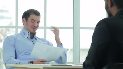 Focused Businessmen Engaged in Negotiations at a Bright Office Table