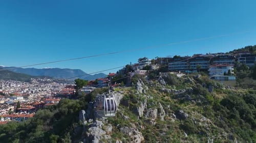 Aerial Video Scenic Cable Car Journey in the Mountains With Views of the Blue Sea and Cityscape