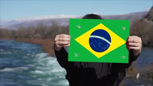 Person, die ein Banner mit der Flagge Brasiliens hält