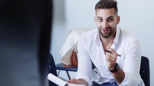 Smiling young male activist leading meeting in office with coworkers