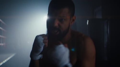 Concentrated African American Man with Hand Wraps Trains in Gym