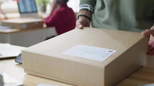 Delivery Service Worker Preparing Parcel for Shipping