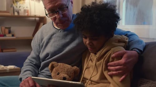 Grandpa and Grandson Watching Film on Digital Tablet