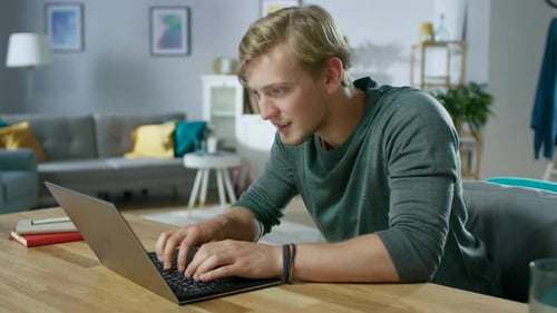 Young Man Working on Laptop in Living Room