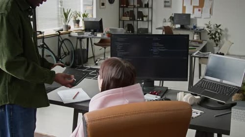 Junior Male Developer Showing Code on Tablet to Strict Female Supervisor