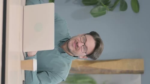 Man Smiling While Using Computer Indoors
