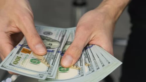 Hands Counting Stack of One Hundred Dollar Bills