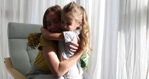 Niña abraza y besa regala flores a mamá