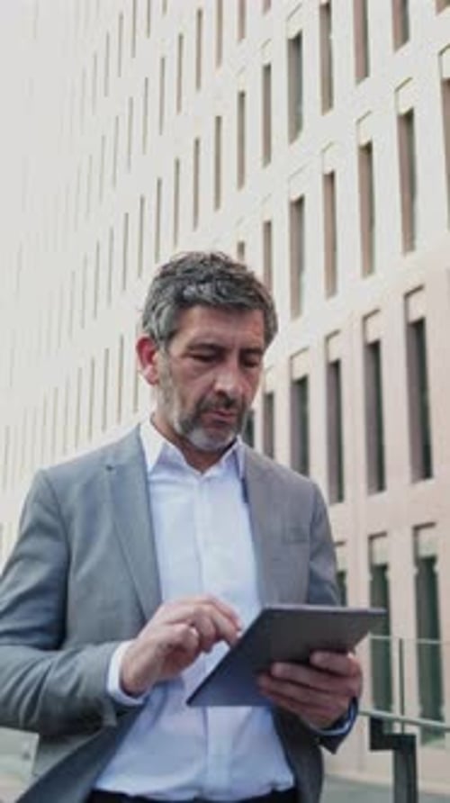 Businessman Using Digital Tablet Outside Office Building