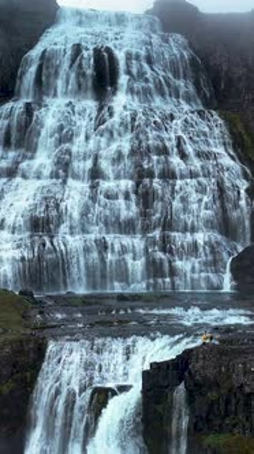 Majestic Waterfall with a Solitary Man Standing Near