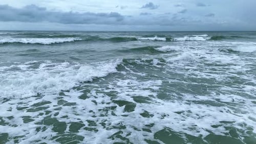 Strong Ocean Waves Breaking Under Cloudy Stormy Sky Drone Video