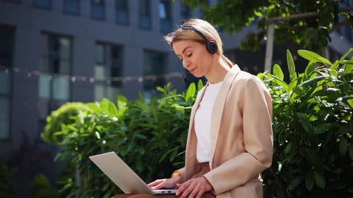 Young Adult Woman on Laptop Video Call Outside