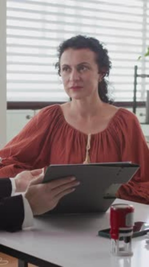 Female Client and Manager Discussing Document in Office