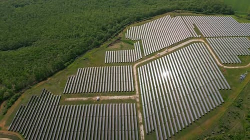 Drone View of a Solar Power Station Next to a Forest During Summer Renewable Energy Meets Nature in