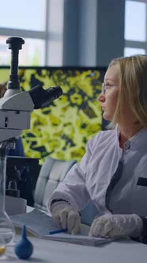 Woman Scientist Works With Microscope in Laboratory