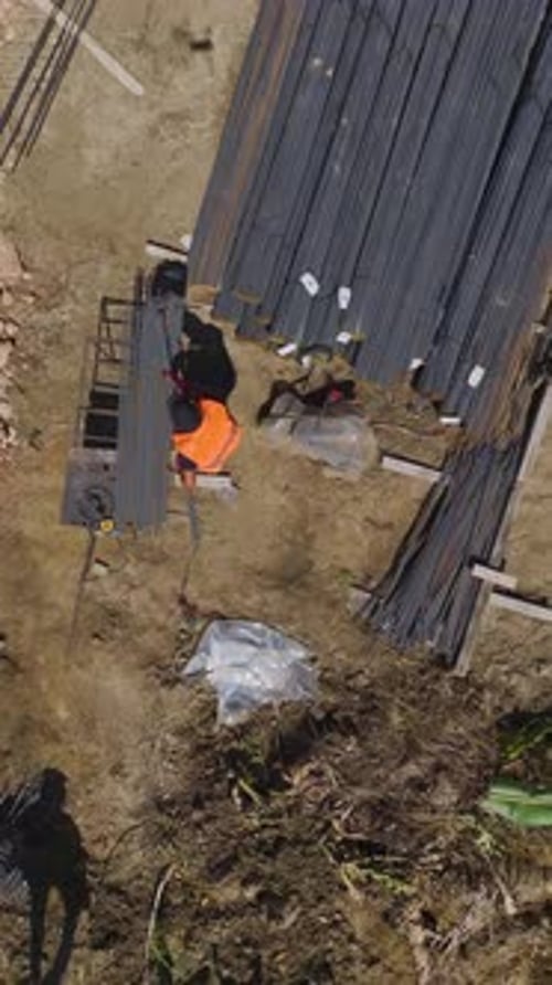 Construction Workers Working with Metal Rebar Rods
