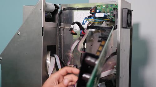 Hombre irreconocible ensamblando una parte eléctrica de un dispositivo Ingeniero de taller de reparación de equipos electrónicos