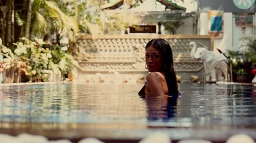 Attractive Woman Relaxing in a Tropical Pool