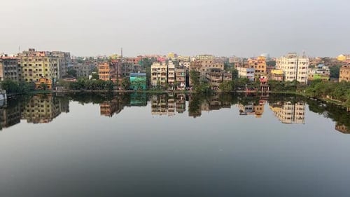 Rows of old buildings or apartments beside a pond in Kolkata, India