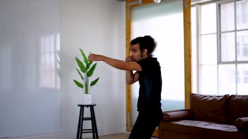 Person Practicing Self-Defense in Modern Living Room