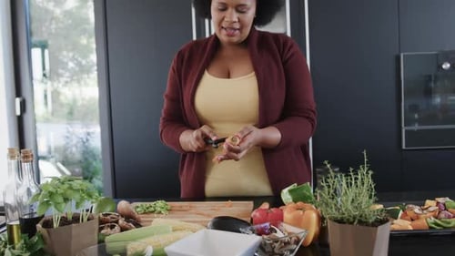 Woman Peeling Carrot While Preparing Vegetables at Home