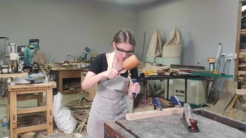 Young female carpenter working in a workshop
