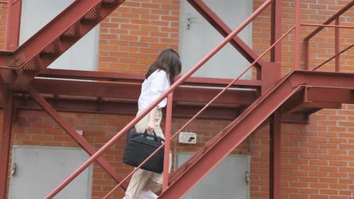 Businesswoman Climbing Up the Stairs of a Business Centre