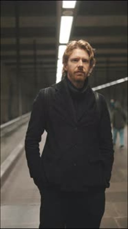Man in Dark Clothes Standing Still in Urban Tunnel