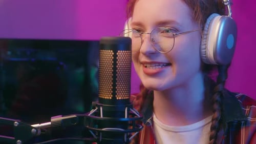 Smiling Young Adult Speaking Into Microphone