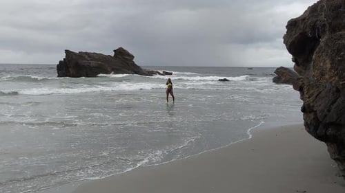 Modelo de bikini bailando y tomando selfies en la costa de esta increíble playa
