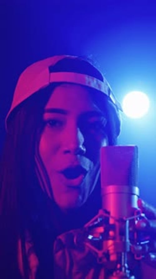 Talented Woman Singing Passionately Into Microphone in Studio