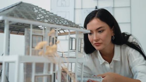 Architect using ruler to measure house model at modern office. Immaculate.