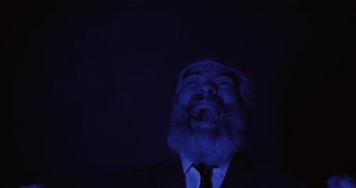 Portrait of Crazy Businessman Laughing in Bright Colorful Light Flashes in Darkness