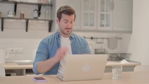 Man Working at Laptop Massages Temples From Headache