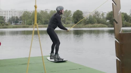 Wakeboard Surfer Jumping off Dock at Cable Park and Starting Ride