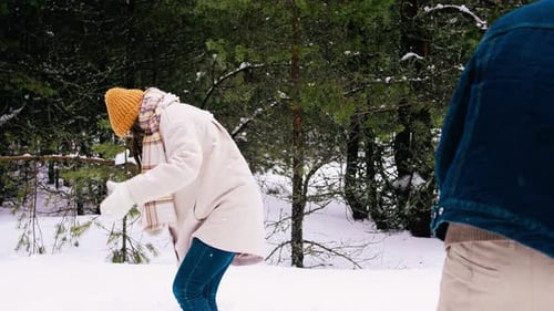 Happy Couple Snowball Fight in Winter Forest