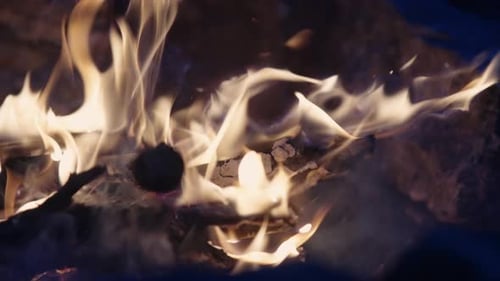 Close-up of fire burning wood in a sizzling hot orange campfire at night, Slow Motion, 4k