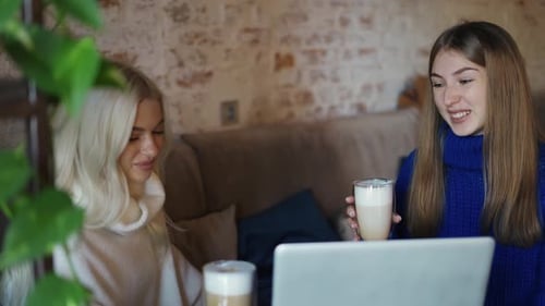 Two Women Talking Over Coffee in Urban Cafe