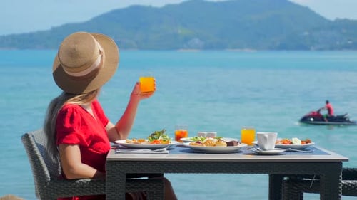 Woman Enjoys Healthy Breakfast with Sea View at Luxury Hotel Resort