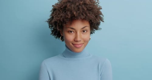 Smiling Woman Winking Against Blue Background