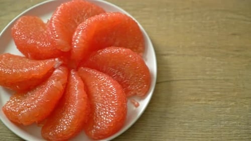 fresh red pomelo fruit or grapefruit on plate