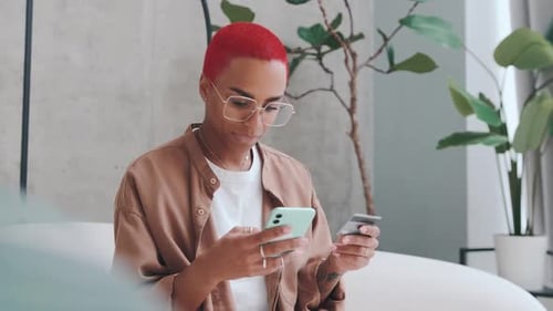 Young African American Woman Holding Credit Card and Using Mobile Phone
