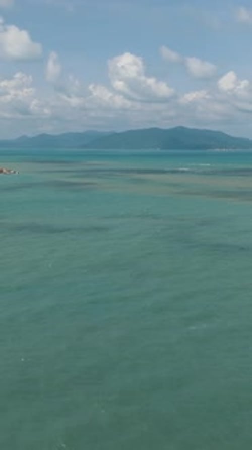 Turquoise Sea with Green Coastline and Distant Mountains Ko Samui Thailand