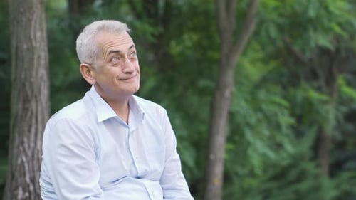 Smiling Man Seated Outdoors in Park