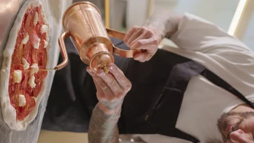 Chef Prepares Pizza with Copper Drizzle